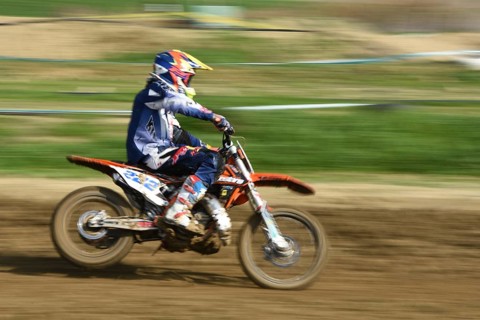 Unrecognized athlete riding a sports motorbike on a motocross racing event. Exreme sports high