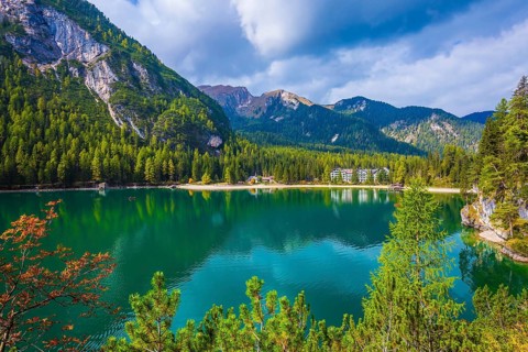 Green water reflects the surrounding mountains and forest. Magnificent lake Lago di Braies. South