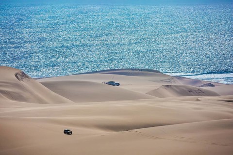 Gorgeous and dangerous jeep - safari through the huge sand dunes on the ocean shore. Atlantic coast