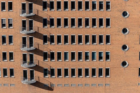 Red brick building with balconies and square and round windows in the Speicherstadt, Hafencity,