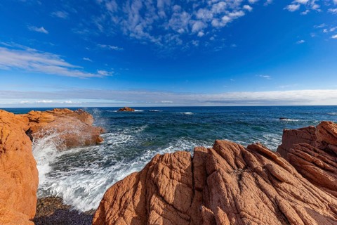 Coastal landscape with red rocks and surf in blue sky and sunshine, Spiaggia di Cala E'Luas,