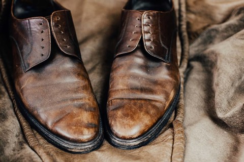 A pair of worn brown leather shoes with a vintage and rustic aura
