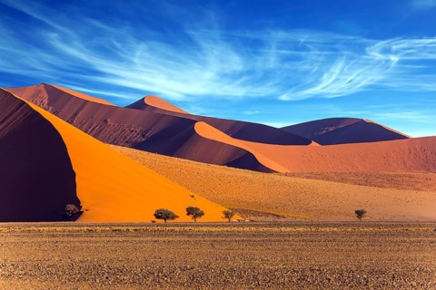 The Namib-Naukluft park at sunset. Sharp border of light and shadow over the crest of the dune. The