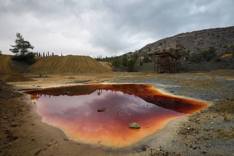 Lake with red polluted toxic water of an Abandoned copper mine at Mitsero area in Cyprus
