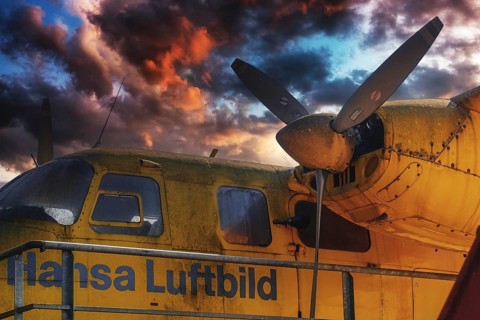 Old yellow aeroplane with propeller and a dramatic cloudy sky at sunset, Aero Commander 680E