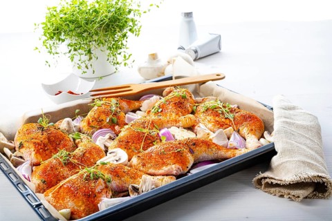 Prepared chicken legs with various vegetables and herbs