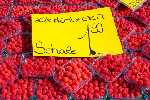 Fresh raspberries in trays with price tag on a market stall for sale, Bremen, Germany, Europe
