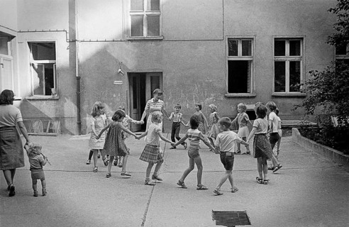 26/04/1983 GDR East Berlin district of Prenzlauer Berg. Children dancing in a circle with their