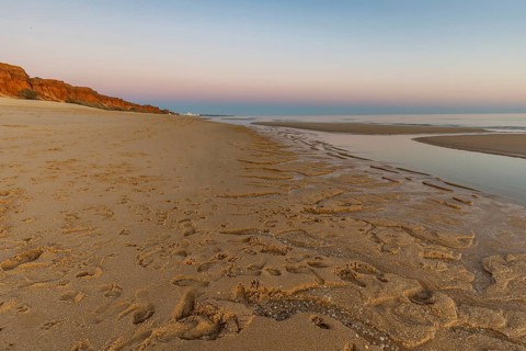 What a sandy beach on the Atlantic. Landscape shot at sunset on a coast with sandstone cliffs. Low