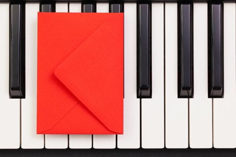 Funny arrangement envelope on the piano keybords - Flat lay image