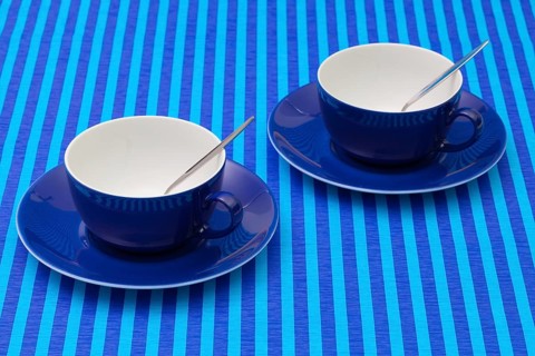 Symmetry arrangement empty cups of tea on blue striped tablecloth. Blue concept