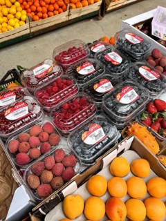 Budva, Montenegro - 25 december 2022: Fresh lychee berries, peaches, currents, raspberry