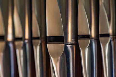 Close-up of lead organ pipes standing in a row in a church