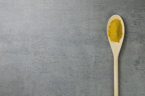 Turmeric spice in wooden spoon