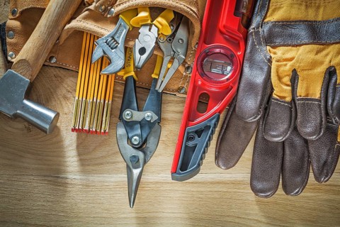 Tool belt with tooling construction level safety gloves on wooden board