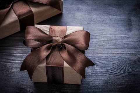 Present boxes with brown tied ribbons on vintage wooden surface