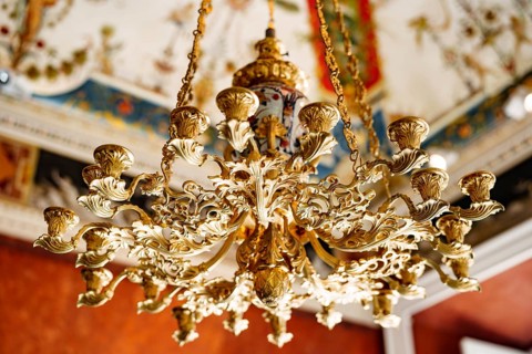 Close-up of an antique gold Italian chandelier. A chandelier-chandelier on gilded chains hangs