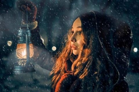Young girl with lantern in winter forest fairy tale, book cover, christmas time