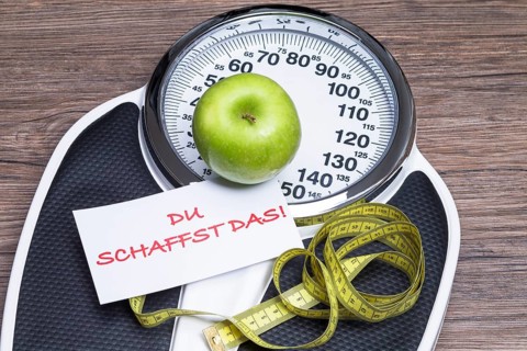 Concept photography for a healthy lifestyle with scales, apple and measuring tape