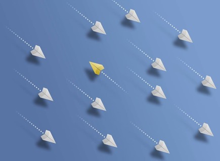 group of paper planes flying in one direction on blue background and one paper glider going in