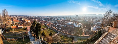 Wide panorama of Graz City, City rooftops, Mur river and city center, Schlossberg hill and clock