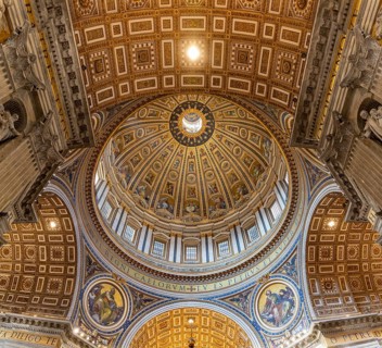 A picture of the huge dome of the St. Peter's Basilica and the surrounding frescoes and