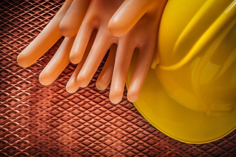 Insulating gloves Construction helmet on dielectric rubber mat
