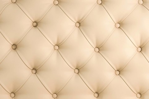 Beige soft tapestry pattern background with symmetrical buttons on the corners of diamonds. Soft