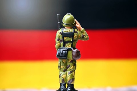 Soldier in front of a German flag, symbolic photo of compulsory military service