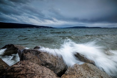 Sprayed waves crash against stones in front of a cloudy sky, harbour, Mittelzell, Reichenau, Lake
