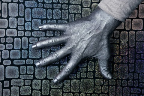 Male futuristic man silver hand over textured steel background