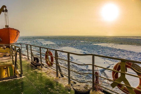 Dim polar sun in Lapland. The concept of active and extreme tourism. The strip of ice crumb spreads