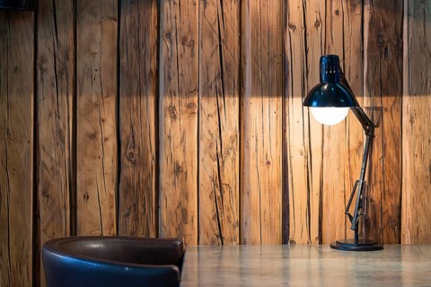 Vintage black desk lamp on wood background Vintage background with lighting retro desk lamp on wood
