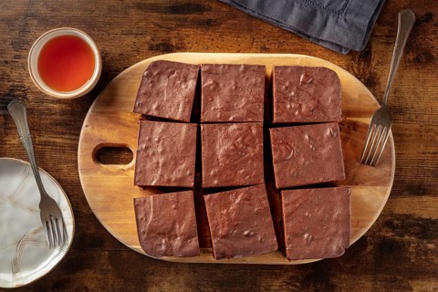 Chocolate brownie with tea, simple coffee cake, overhead flat lay view on a dark rustic wooden