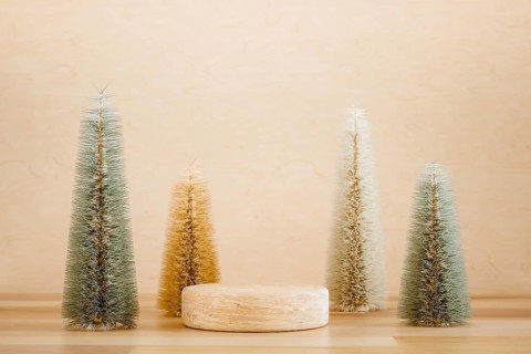 Wooden podium pedestal product mockup display with miniature Christmas trees in beige and green, 3d