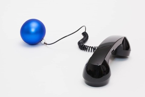 Old phone reciever and cord connection with Christmas decoration. Christmas hotline concept