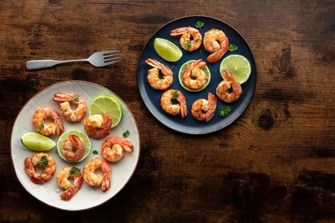 Shrimps, overhead flat lay shot on a rustic wooden background, with copy space. Cooked shrimp with