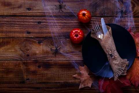 Halloween table setting on old rustic wooden table. Holiday card template