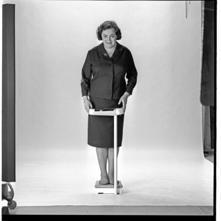 Woman in the 1960s. She is standing and weighs herself on a scale. Sweden november 1965