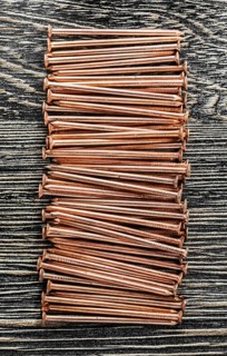 Stack of copper nails on wooden board