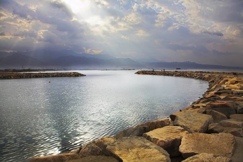 Solar beams above a lagoon in Red sea, fenced by an artificial pier