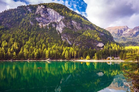 Magnificent lake Lago di Braies. Emerald expanse of water reflects the surrounding forest and