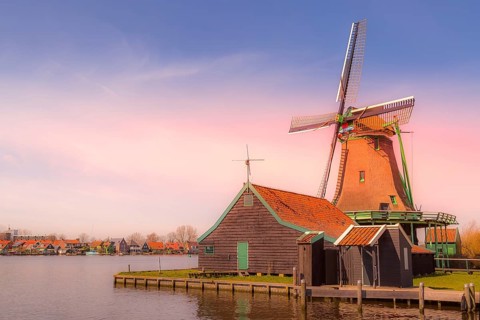 Zaanse Schans, Netherlands pink sunset panoramic view of windmills and lake in traditional village