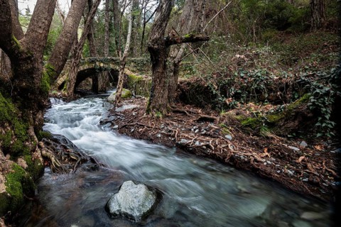 Beautiful medieval stoned bridge or Milia with river full with water flowing at Troodos mountains
