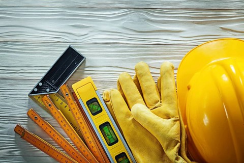 Protective gloves try square construction level wooden meter hard hat on wood board