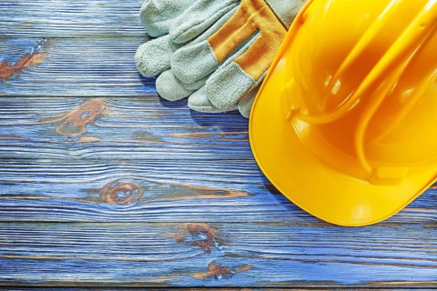 Safety gloves hard hat on vintage wooden board