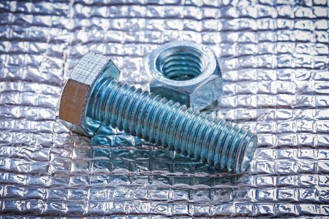 Stainless bolt and screw nut on metal background construction concept