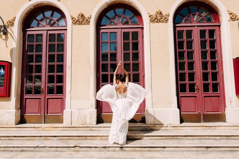 Sibenik, Croatia - 05.06.17: Bride in a white dress fluttering in the wind stands in front of high