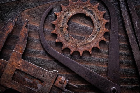 Set of rusty measuring calipers with cog- wheel on vintage dark wooden surface construction concept