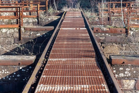 Rusted metal walkway in an industrial setting with grid pattern
